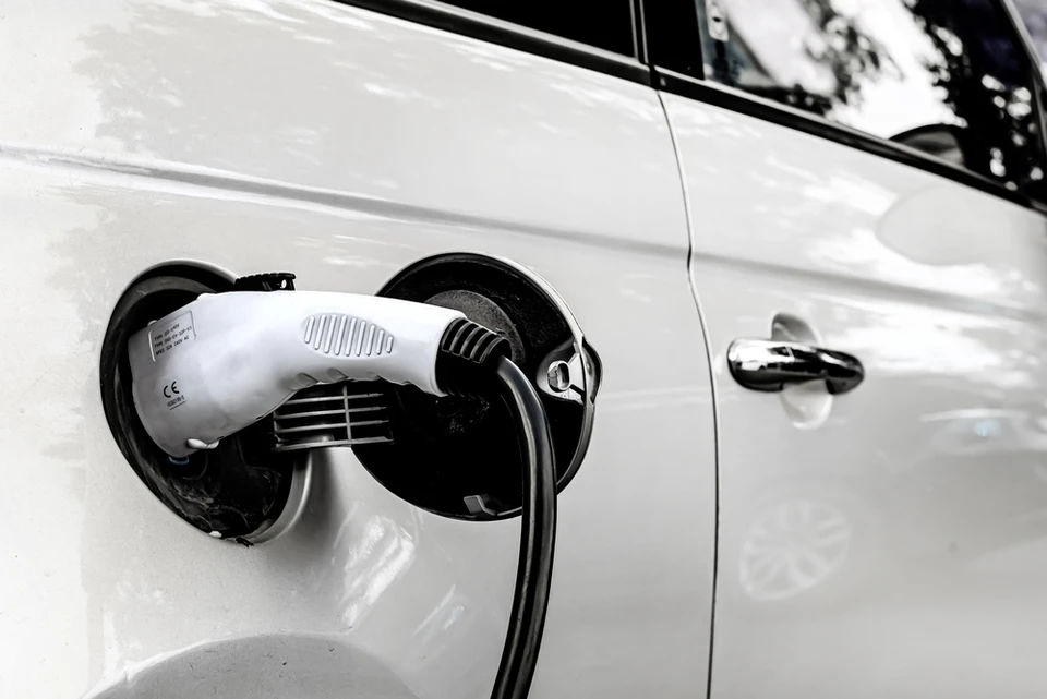 Véhicule électrique blanc en cours de recharge à l'extérieur