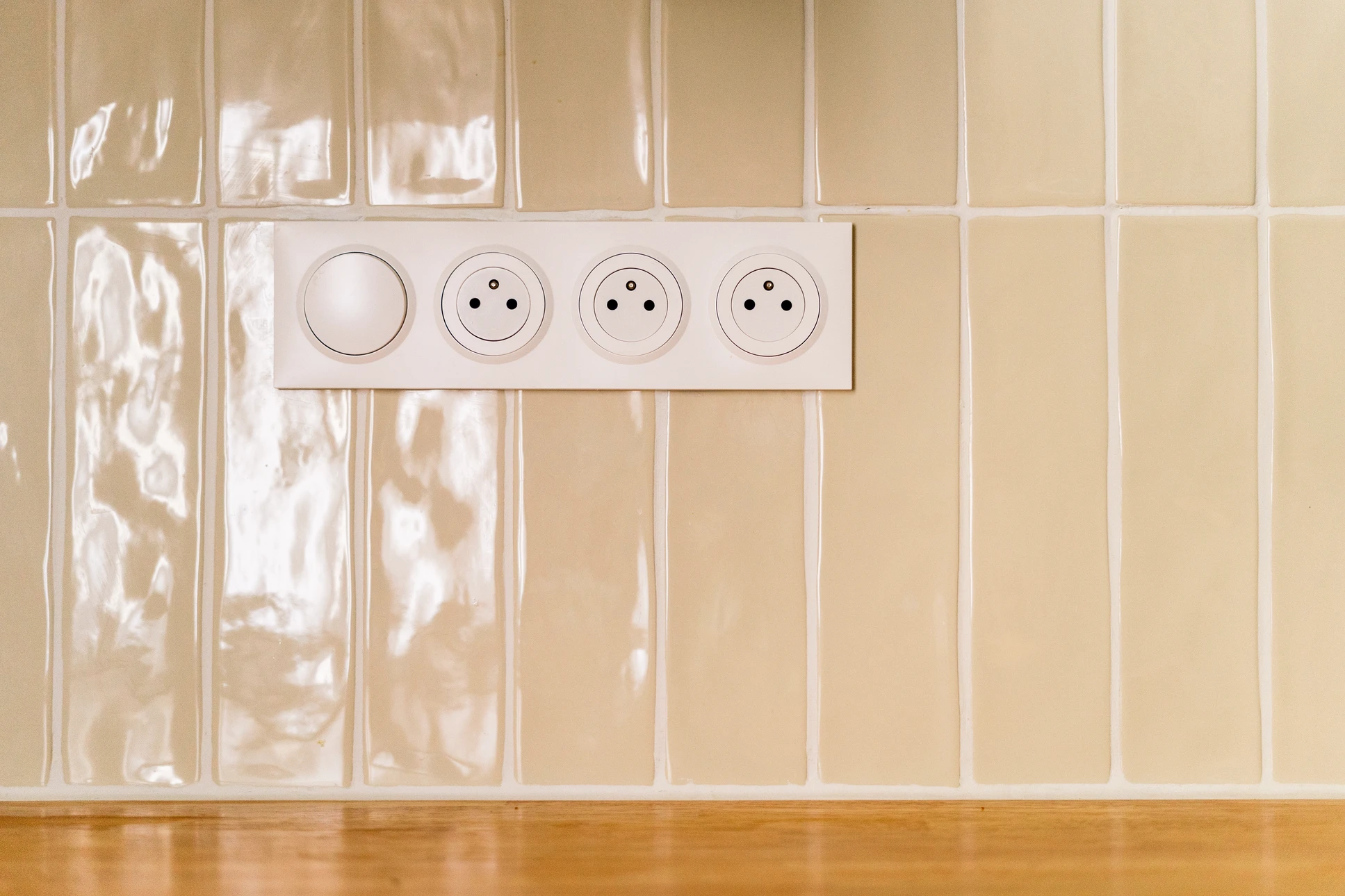 Un électricien installe une prise électrique murale dans un intérieur résidentiel