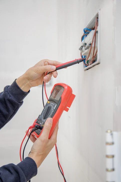 Homme travaillant dans un interrupteur à lumière en testant l'énergie dans le noir, tablette montrant une carte électrique